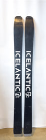 A pair of black Icelantic Demo - 23/24 Natural 101 skis, each featuring the word "ICELANTIC" and a white logo, stand upright against a white background. Handmade in Colorado, these lightweight skis deliver exceptional performance for backcountry touring enthusiasts.