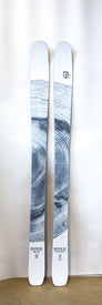A pair of lightweight Icelantic Demo - 23/24 Mystic 97 skis in white, featuring a gray woodgrain ring pattern, stand upright against a white background. Designed for women's backcountry touring, these skis display the Icelantic logo and other small branding near the bases.