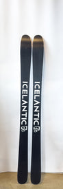 A pair of black Demo - 23/24 Riveter 85 all-mountain skis from Icelantic, featuring white branding, stand upright against a plain white background on a concrete floor—an ideal choice for women seeking versatile performance.