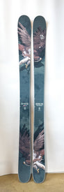 A pair of Icelantic Demo - 23/24 Nomad 105 skis showcases a striking graphic of a soaring eagle with outstretched wings and talons, set against a dramatic cloudy sky background.