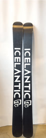 A pair of black Icelantic Demo - 23/24 Maiden 111 powder skis stands upright against a plain white background, with the brand name ICELANTIC printed in bold white letters on each ski. Designed as a women’s freeride ski, the Demo - 23/24 Maiden 111 delivers performance and style for deep snow adventures.