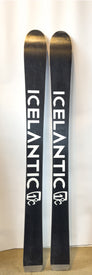 A pair of Demo - 23/24 Shaman 2.0 110 skis by Icelantic, in black, standing upright against a white background with the brand name ICELANTIC displayed in bold white letters on each ski.