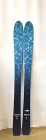 A pair of Icelantic Demo - 23/24 Shaman 2.0 99 skis, showcasing a blue water ripple pattern, stands upright against a plain white background.