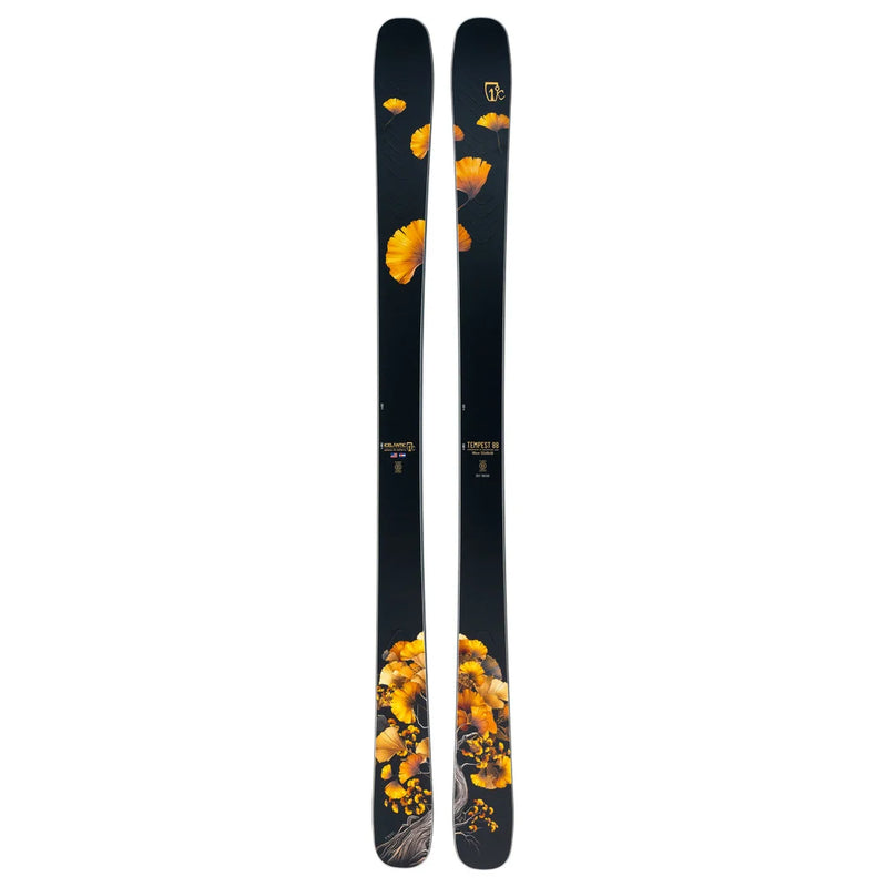 A pair of Icelantic Skis Tempest 88 black skis featuring a pattern of yellow-orange flowers and leaves arranged near the tips and bases, gradually fading toward the center.