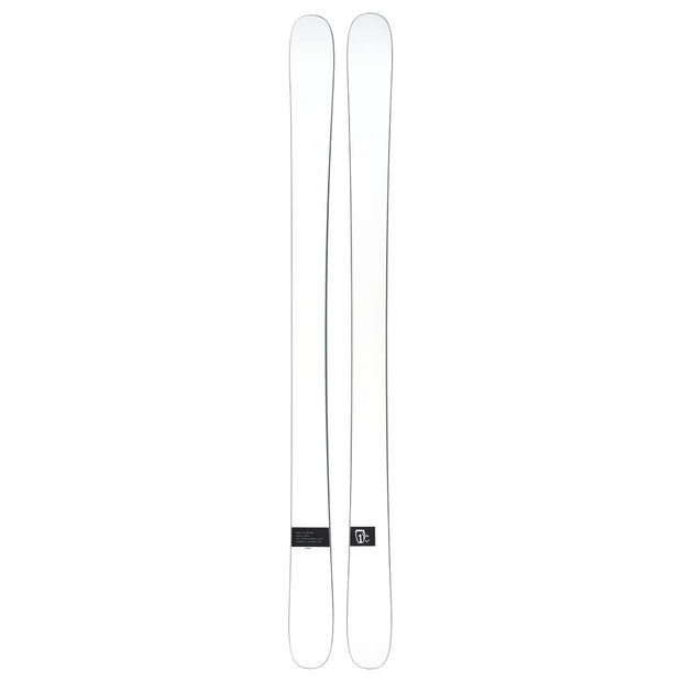 A pair of Icelantic Skis Nomad 100 Whiteout are placed side by side on a plain background, featuring minimal markings and a small logo near the base of one ski.