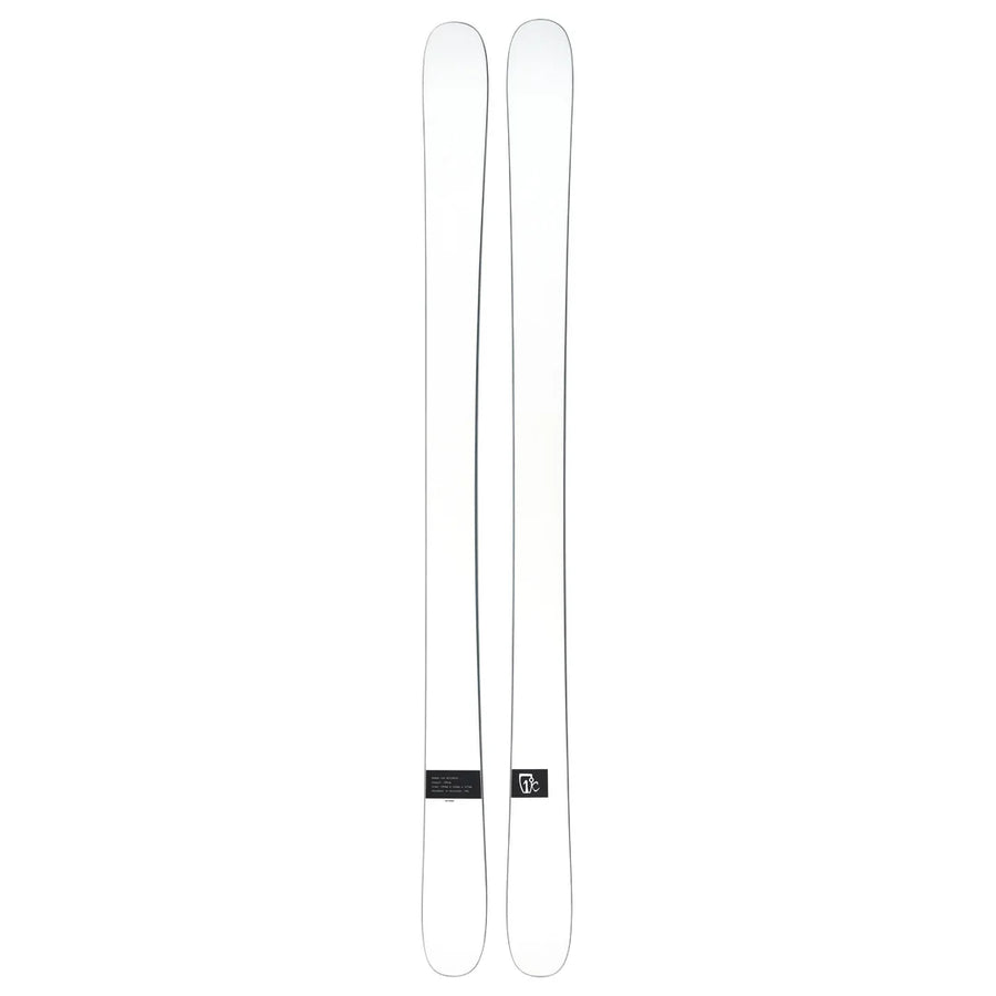 A pair of Icelantic Skis Nomad 100 Whiteout are placed side by side on a plain background, featuring minimal markings and a small logo near the base of one ski.