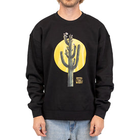 A person is wearing the Cactus Crew by Icelantic Skis, a black unisex crewneck sweatshirt crafted from recycled polyester fleece. This standout piece features a cactus graphic with a yellow circle in the background and the text "INTO THE WEST," styled here with light blue jeans by the Nomad 106 crew.