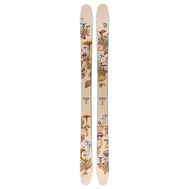 A pair of Icelantic Nia Pro 105 unisex skis in beige, handmade in Colorado and featuring an illustrated pattern of colorful mushrooms and autumn leaves along the length of each ski.