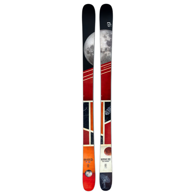 A pair of Icelantic Skis Nomad 100 featuring a vibrant, geometric design with a prominent full moon at the top, red and orange hues, and abstract patterns running along their length.