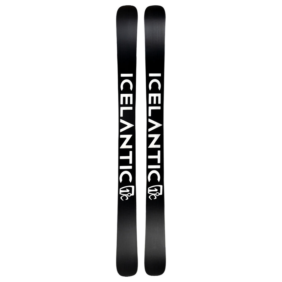 Two black Nomad 112 Whiteout skis by Icelantic Skis placed side by side, each featuring the word ICELANTIC printed vertically in bold white letters and a small white logo near the bottom—engineered as a top-tier freeride ski for advanced skiers seeking performance on any terrain.