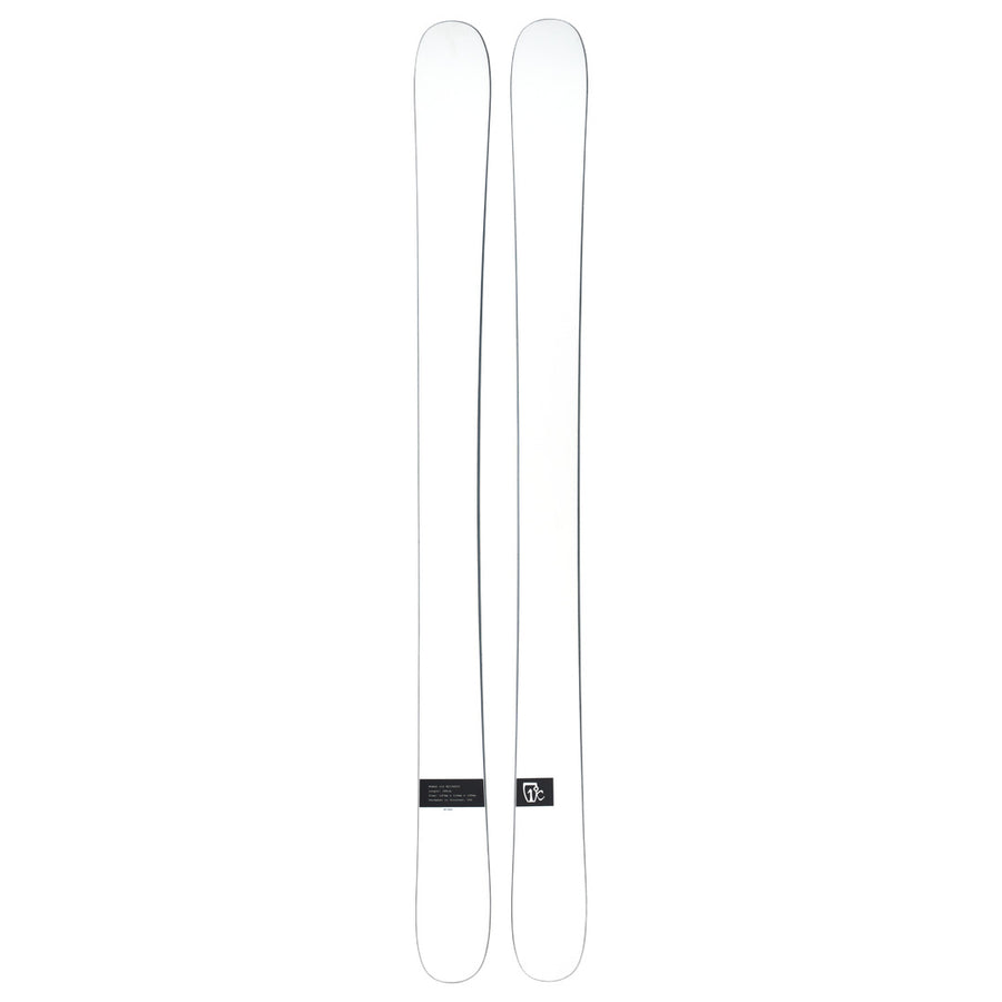 A pair of Icelantic Skis Nomad 112 Whiteout freeride skis, featuring a plain white design with a small black rectangular label near the tail on one ski, shown side by side on a white background.
