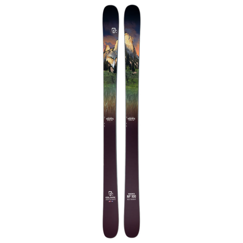 A pair of Icelantic Skis Yosemite NP 100 all-mountain skis, handmade in Colorado, featuring a scenic landscape graphic with mountains, green trees, and a sunset sky. The skis transition from a dark base to lighter tones toward the top, with logos and model information displayed near the bottom.