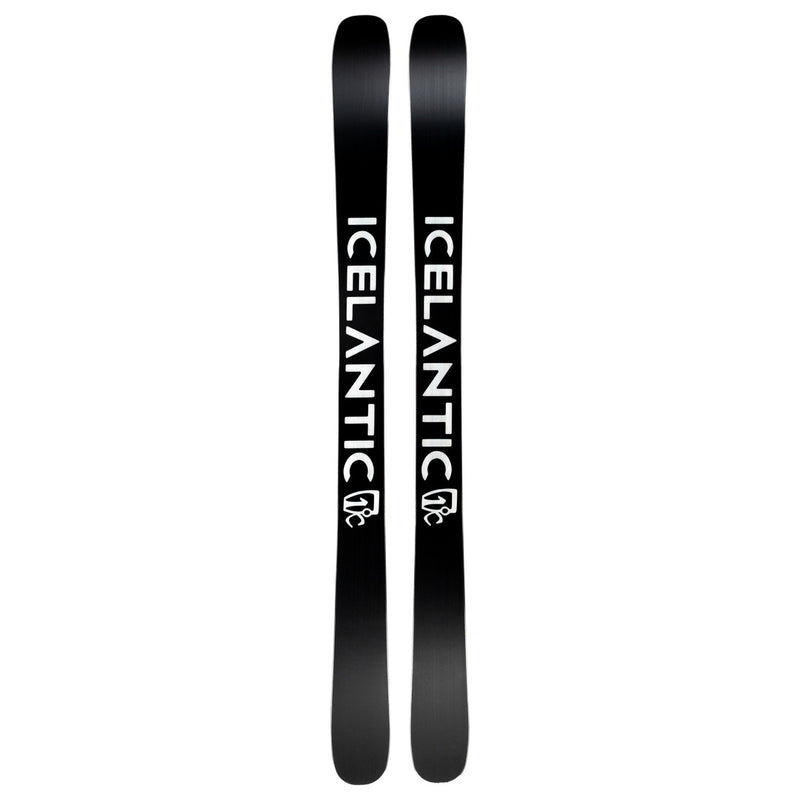 A pair of Icelantic Skis Tempest 100 all-mountain skis feature the word ICELANTIC in bold white letters along their black surface, with a white logo beneath the text on each ski. Built with a poplar and birch wood core reinforced by a carbon matrix, these skis deliver both strength and versatility across any terrain.