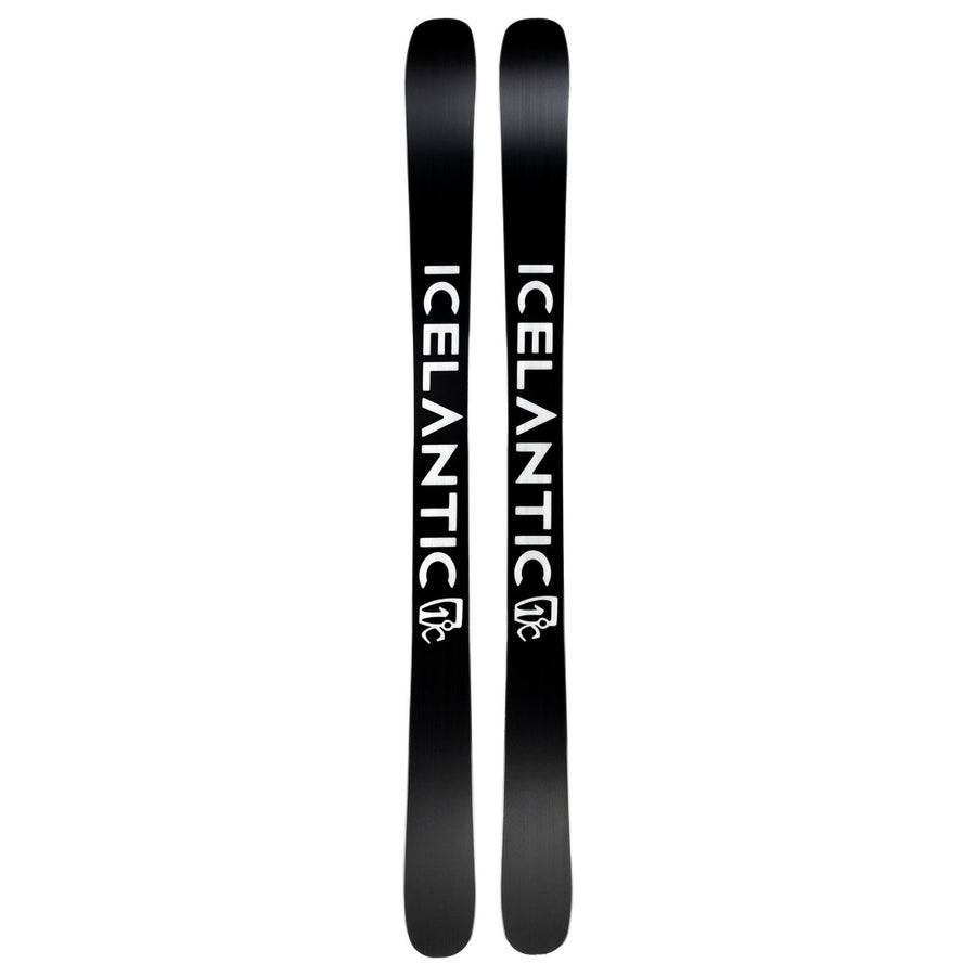 A pair of Icelantic Skis Tempest 100 all-mountain skis feature the word ICELANTIC in bold white letters along their black surface, with a white logo beneath the text on each ski. Built with a poplar and birch wood core reinforced by a carbon matrix, these skis deliver both strength and versatility across any terrain.