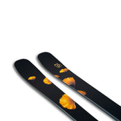 A pair of Tempest 88 skis by Icelantic Skis, featuring a black base adorned with yellow-orange ginkgo leaf patterns near the tips, set against a white background.