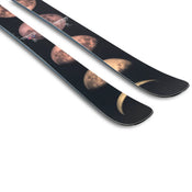 A pair of Icelantic Skis Maiden 102 black skis featuring a design of the moon’s phases, from crescent to full moon, printed along the top surface near the tips.