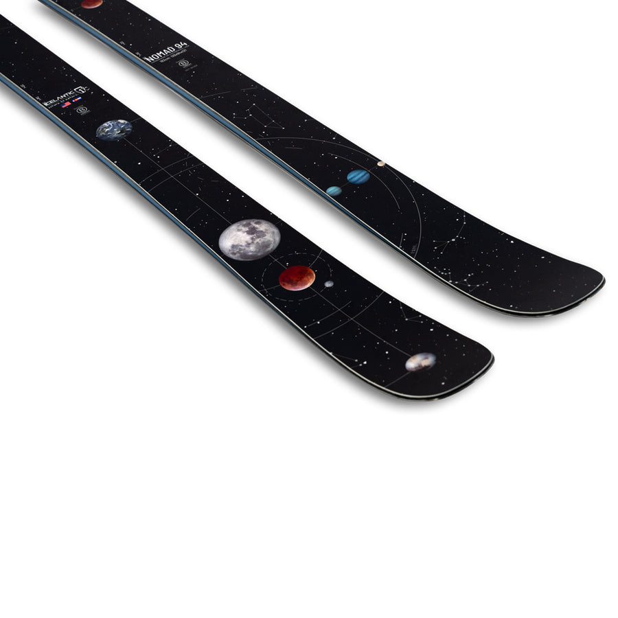 The Icelantic Skis Nomad 94 is a pair of black skis adorned with a space-themed design featuring planets, the moon, and stars scattered along the top surface.