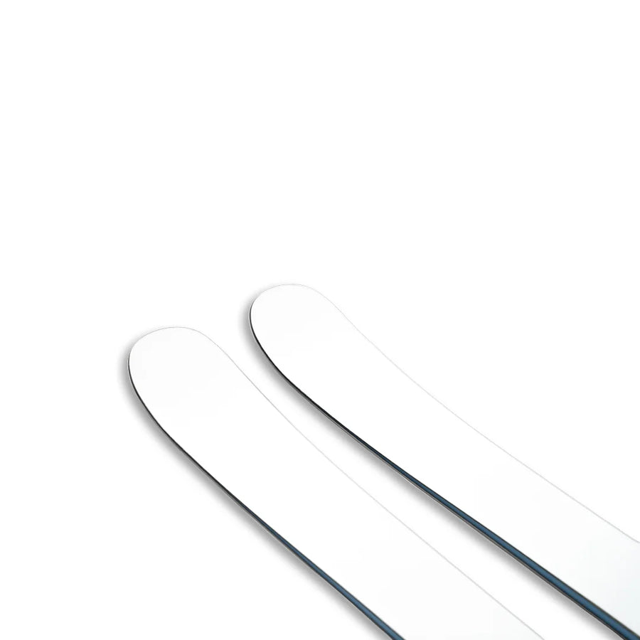 The Icelantic Skis Nomad 100 Whiteout, featuring two white skis with rounded tips, are positioned side by side on a white background and are partially visible from the top right corner.