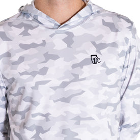 A person is shown wearing the Icelantic UV Sun Hoodie - Snow Camo, featuring a white and light gray geometric camouflage pattern and a small black logo on the left chest. Only the neck and upper torso are visible. This UPF 50, quick-dry hoodie delivers both style and superior sun protection.