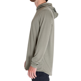 A man is shown in profile facing left, wearing the Icelantic UV Sun Hoodie in Olive Grey with UPF 50 protection, paired with black pants. The background is plain white.