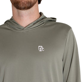 A person wearing the Icelantic UV Sun Hoodie in Olive Grey, which features a small white chest logo. The UPF 50 fabric provides excellent sun protection. The image displays the lower face, neck, and upper torso, but does not show the full face.