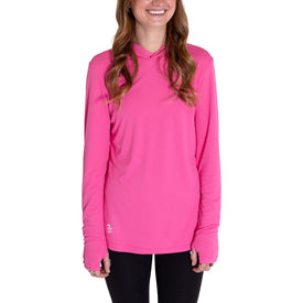 A smiling woman wearing the Icelantic Womens UV Sun Hoodie in Hot Pink, featuring UPF 50 sun protection, and black pants, stands with her arms relaxed by her sides.