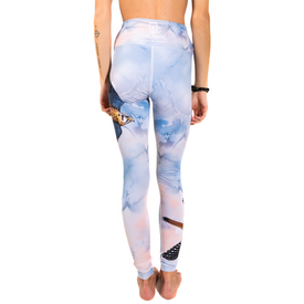 A person stands barefoot, facing away, wearing Icelantic 23/24 Soaring Kestrel Leggings—high-waisted, pastel-colored leggings adorned with animal and nature prints such as an eagle and a bird. Made from Hyper Wiking WIKMAX Fabric with a supportive high-waist waistband for comfort and style, their arms rest relaxed by their sides, one featuring a tattoo.