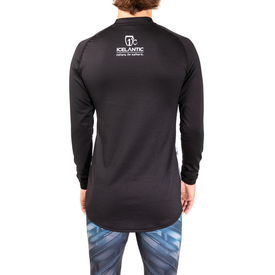 A person is facing away, wearing the Icelantic 23/24 Men's WikMax Baselayer Top in black, which features the Icelantic return to nature logo on the upper back, paired with patterned blue leggings. The background is plain white.