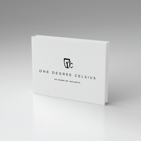A minimalist white hardcover book titled One Degree Celsius: 20 Years of Icelantic by Icelantic Skis stands upright against a neutral gray background, featuring black text and a small logo above the title that reflects the art-driven spirit of the brand.