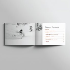 An open book displays a black-and-white photo of a skier gliding through deep snow on the left page—a striking image that embodies the spirit of Icelantic Skis. On the right, the Table of Contents for "One Degree Celsius: 20 Years of Icelantic" lists chapters and page numbers, inviting readers on a journey where adventure meets artistry.