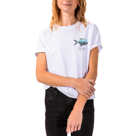 A woman wearing the Icelantic Permit Tee—crafted from GOTS certified organic cotton and featuring a small, colorful fish and the word "Key West" on the chest—paired with black jeans, stands against a white background.