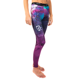 A person stands barefoot on a white background, wearing the Icelantic 23/24 Womens WikMax Baselayer Full Bottom—leggings featuring a colorful, abstract pattern in purple, blue, and pink, and crafted from WIKMAX fabric.