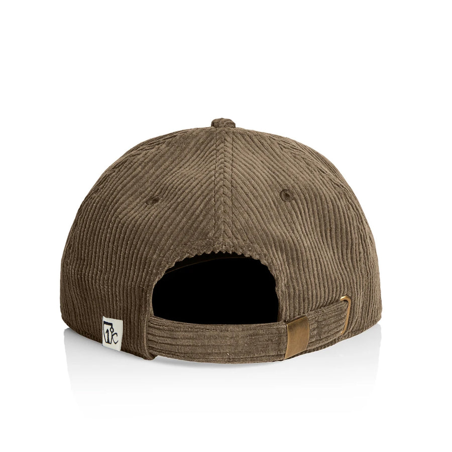 Script Cord Cap - Walnut by Icelantic Skis viewed from the back, featuring an adjustable strap and a small white tag with an embroidered logo on the left side. The background is white.