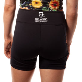 A person wears the Icelantic Skis Sunflower Pocket Short, featuring the ICELANTIC return to nature logo on the waistband. Crafted from recycled fabric for an eco-friendly touch, these women's summer shorts are perfect for staying comfortable and stylish. The person's hands rest relaxed at their sides against a white background.