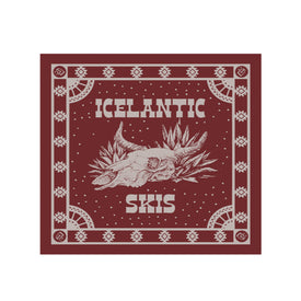 The Agave Skull Bandana by Icelantic Skis is a maroon square bandana crafted from lightweight cotton, featuring a white illustration of a cow skull surrounded by plants. "ICELANTIC" is printed above the design and "SKIS" below. Made in Denver, it’s finished with a geometric decorative border that frames the artwork.