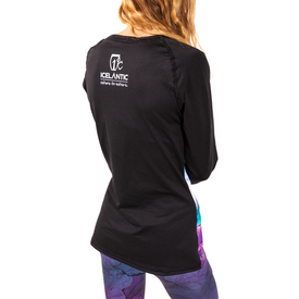 A woman is seen from behind, wearing the Icelantic 23/24 Womens WikMax Baselayer Top in black from the Riveter Collection, featuring the ICELANTIC Return to Nature logo on the back and paired with colorful leggings, set against a white background.