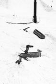 Riding the Icelantic Skis Nomad 94 Whiteout, a skier in mid-trick slides along a curved metal rail in a snowy terrain park, surrounded by snow and ski features.