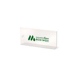The mountainFLOW Eco Wax Kit by Icelantic Skis includes a clear rectangular plastic scraper with a small hole in one corner and the green mountainFLOW eco-wax logo printed on it, shown against a white background—an ideal tool for applying plant-based ski wax or biodegradable snowboard wax.