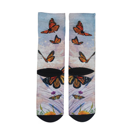 Icelantic 22/23 Maiden Socks showcase a colorful lifestyle design with orange and black monarch butterflies fluttering above grass and flowers. Inspired by Travis Parr’s vibrant style, these socks feature a soft pastel background, complemented by black toe and heel areas.