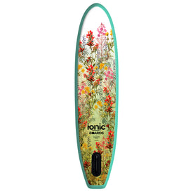 A paddleboard with a mint green border and a floral design featuring red, yellow, and pink flowers. The board showcases Icelantic Skis branding as the Ionic X Parr Paddleboard - Yoga Green and includes a fin slot at the bottom, making it an ideal all-water paddleboard for versatile adventures.