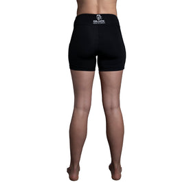 A person stands barefoot, facing away from the camera, wearing the Icelantic Skier Pocket Short in Black/Pink, featuring a white Icelantic Mountain Athletic logo on the waistband. The background is plain white.