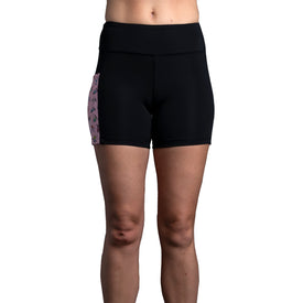 A model showcases the Icelantic Skier Pocket Short in Black/Pink, featuring a pink patterned side panel and made from recycled fabric, with only the lower torso and legs visible against a plain white background.