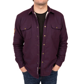 A person wearing the Icelantic Sherpa Lined Jacket in dark purple over a black t-shirt and blue jeans, standing with hands in pockets against a white background.