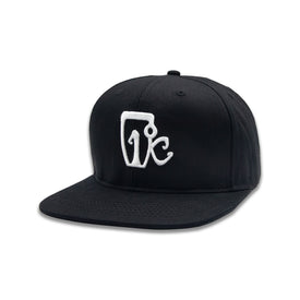The Icelantic One Degree Snapback Hat - Black/White is a classic flat-brimmed baseball cap made from premium cotton twill, showcasing a distinctive white embroidered abstract logo on the front. This timeless hat seamlessly blends modern comfort with iconic style.
