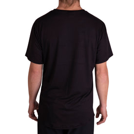 A person with light skin and long hair is seen from the back, wearing the Icelantic Skis SoftTECH T in black—a comfortable, plain t-shirt—standing against a white background.