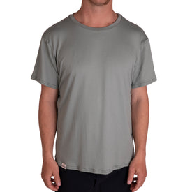 A person wearing an Icelantic SoftTECH T - Greenish short-sleeve t-shirt and black pants stands facing forward against a white background.