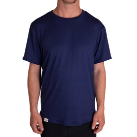 A person wearing the Icelantic SoftTECH T in navy—a plain, short-sleeve t-shirt with advanced wicking and antimicrobial properties—paired with black pants, standing against a white background.