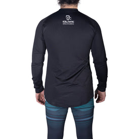 A person stands facing away, wearing the Icelantic 22/23 Men's WikMax Baselayer Top from the Pioneer Collection, featuring ICELANTIC and a logo on the back, paired with patterned blue and black athletic leggings made from WIKMAX fabric.