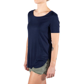 A person is shown from the torso to upper legs, wearing the Icelantic Skis Eco Bamboo T - Navy, an odor-resistant short-sleeve shirt, paired with olive green shorts. Their arms are relaxed and their face is not visible.